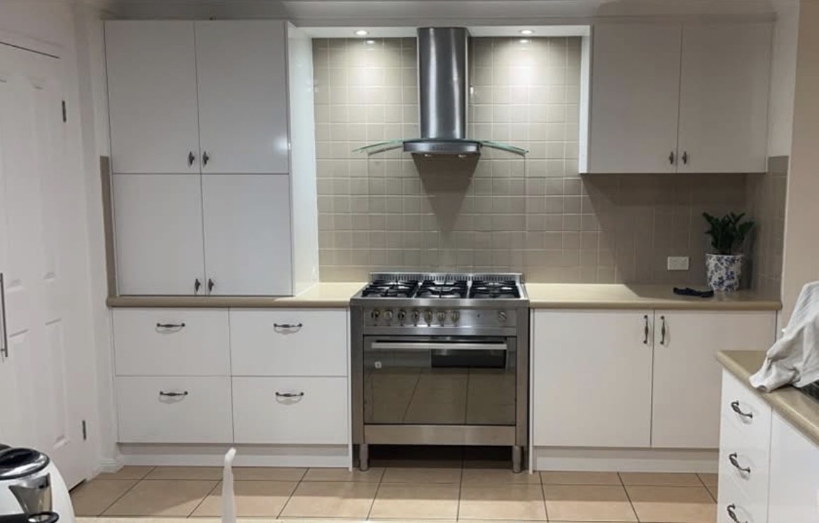 The same kitchen after, with new white doors and drawers